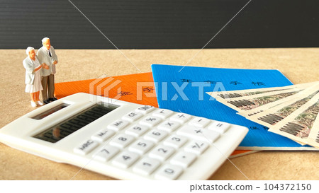 Elderly couple miniature, pension book, calculator and money 104372150