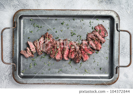 Sliced Grilled Machete skirt beef meat steak. Gray background. Top view. Copy space 104372844