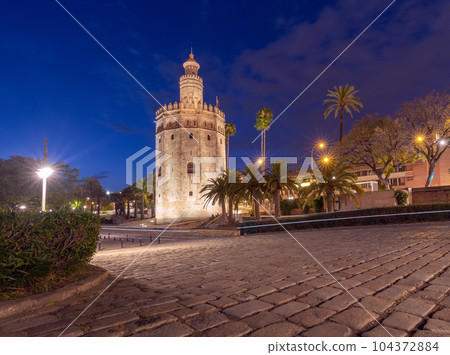 The golden tower of Torre del Oro in night illumination at sunset. The golden tower of Torre del Oro in night illumination at sunset. 104372884