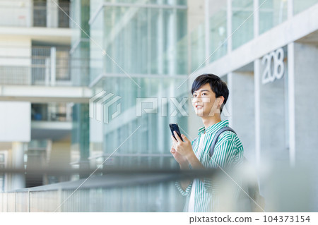 College student walking with smartphone College student walking with smartphone 104373154