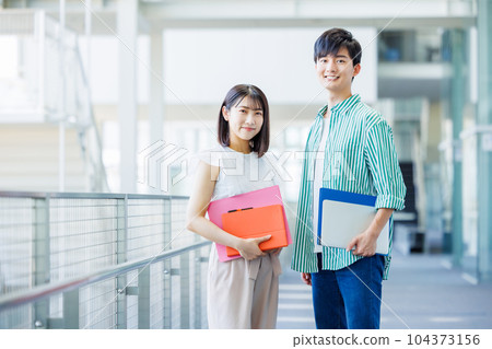Male and female college students walking on campus Male and female college students walking on campus 104373156
