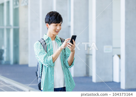 College student walking with smartphone 104373164