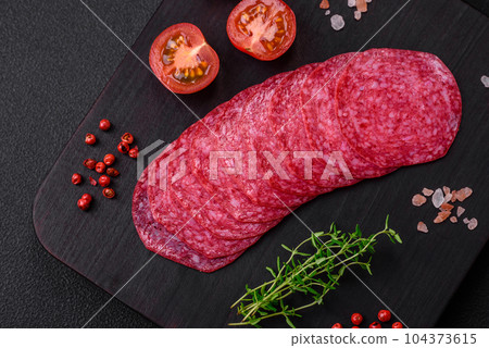 Delicious smoked salami sausage with salt, spices and herbs cut into slices 104373615