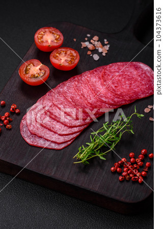 Delicious smoked salami sausage with salt, spices and herbs cut into slices 104373616