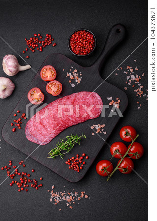 Delicious smoked salami sausage with salt, spices and herbs cut into slices 104373621