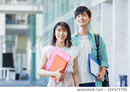 Male and female college students walking on campus 104373766