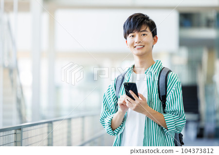 College student walking with smartphone 104373812