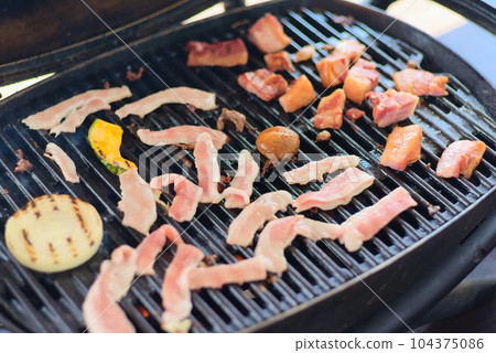 A scene of grilling meat and vegetables on a barbecue A scene of grilling meat and vegetables on a barbecue 104375086