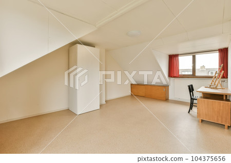 an empty room with red curtains on the window and desk in the room is very clean, but it's no longer than 104375656