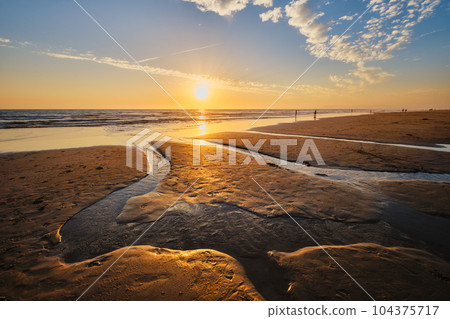 Atlantic ocean sunset with surging waves at Fonte da Telha beach, Costa da Caparica, Portugal 104375717