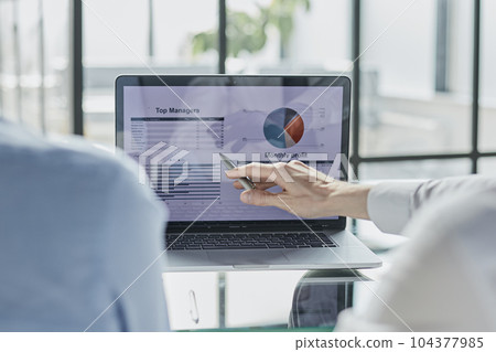 Business partnership coworkers using a tablet to chart company financial statements report and profits work progress and planning in office room. 104377985