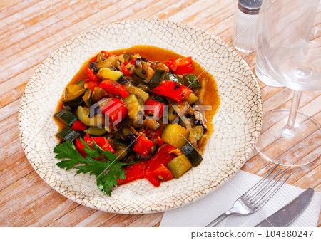 Plate of stewed vegetables on table. Vegetarian dish 104380247