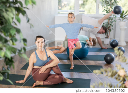 Family with two children doing yoga with softballs Family with two children doing yoga with softballs 104380602
