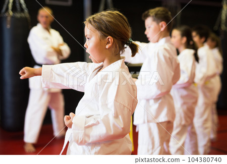 Group of girls and boys in kimono doing kata 104380740