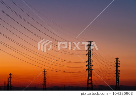 The silhouette of the power transmission towers and the gradation of the evening sky b-2 warm color 104380908