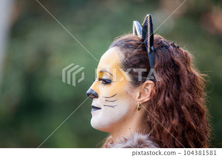 Beautiful young woman wearing a wolf costume. Real family having fun while using costumes of the Little red riding hood tale in Halloween. Beautiful young woman wearing a wolf costume. Real family having fun while using costumes of the Little red riding hood tale in Halloween. 104381581