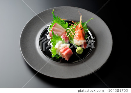 Sashimi | Tuna, amberjack, sweet shrimp, squid | Round plate | Black background | Luxury Sashimi | Tuna, amberjack, sweet shrimp, squid | Round plate | Black background | Luxury 104381703