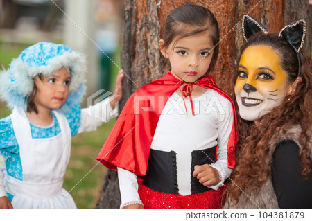 Real family having fun while using costumes of the Little red riding hood tale in Halloween. Real family having fun while using costumes of the Little red riding hood tale in Halloween. 104381879