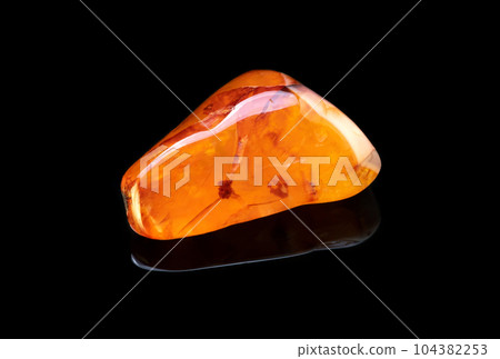 Macro mineral stone Carnelian with reflection on black background 104382253
