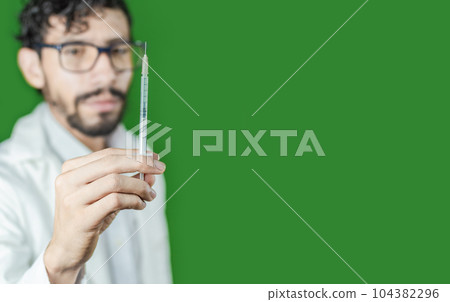 Close-up of a doctor's hand holding a syringe, Close-up of a hand holding an injection on an isolated background, Doctor and syringe concept Close-up of a doctor's hand holding a syringe, Close-up of a hand holding an injection on an isolated background, Doctor and syringe concept 104382296