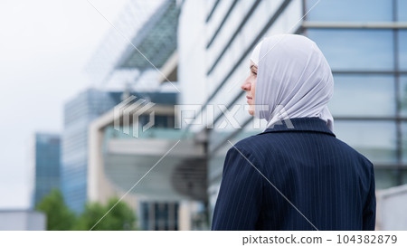 Back view of business woman in hijab and suit on the street. Back view of business woman in hijab and suit on the street. 104382879
