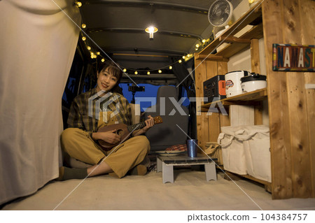A young woman relaxing in her car at an auto-camping site at night Image of sleeping in a car 104384757