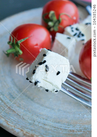 greek feta cubes with tomato diced soft cheese on plate  104385246