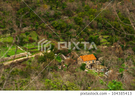 Mountain village with tiled roofs in the Bay of Kotor. Trekking in spring. Mountain village with tiled roofs in the Bay of Kotor. Trekking in spring. 104385413