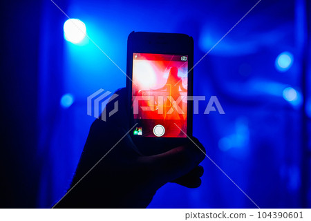 man's hand with a smartphone takes pictures of a dancer's ass man's hand with a smartphone takes pictures of a dancer's ass 104390601