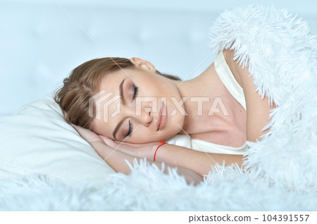 young woman lying on soft bed in the bedroom young woman lying on soft bed in the bedroom 104391557