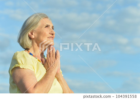 beautiful elderly woman laughing against the sky beautiful elderly woman laughing against the sky 104391558