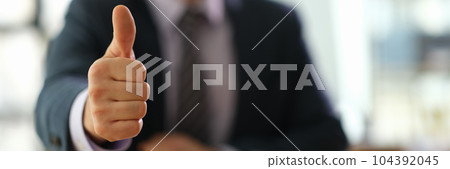 Manager businessman showing gesture thumb up at work in office closeup Manager businessman showing gesture thumb up at work in office closeup 104392045