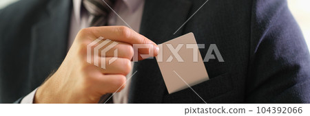 Businessman taking out business card from his jacket pocket closeup Businessman taking out business card from his jacket pocket closeup 104392066