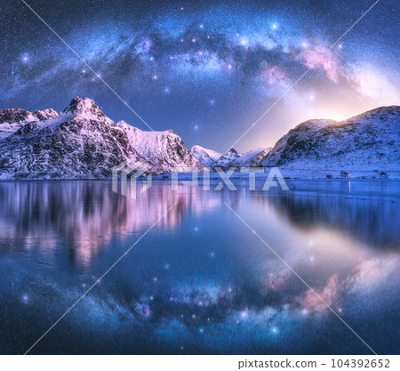 Milky Way arch above sea coast and snow covered mountains 104392652