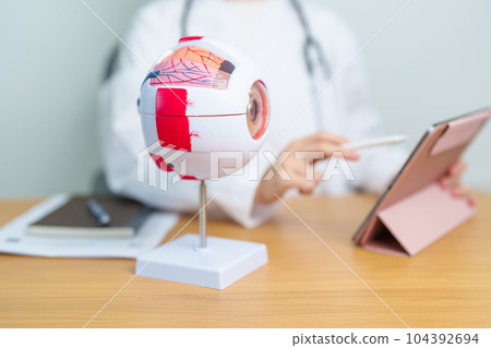 Doctor with human Eye anatomy model with magnifying glass. Eye disease, Refractive Errors, Age Related Macular Degeneration, Cataract, Diabetic Retinopathy, Glaucoma, Amblyopia, Strabismus and Health Doctor with human Eye anatomy model with magnifying glass. Eye disease, Refractive Errors, Age Related Macular Degeneration, Cataract, Diabetic Retinopathy, Glaucoma, Amblyopia, Strabismus and Health 104392694