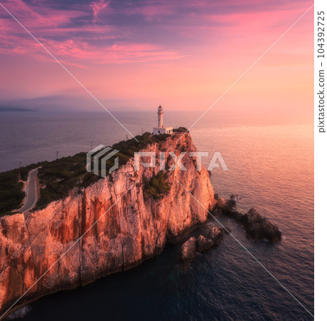 Lighthouse on the mountain peak at colorful sunset in summer 104392725