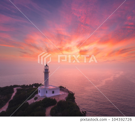 Lighthouse on the mountain peak at colorful sunset in summer 104392726