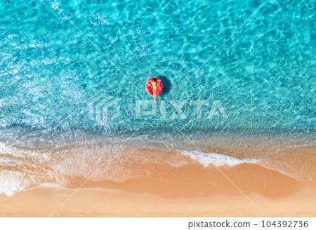 Beautiful seascape with woman with red swim ring in blue sea Beautiful seascape with woman with red swim ring in blue sea 104392736