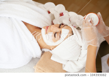 Young beautiful girl receiving facial mask in spa beauty salon Young beautiful girl receiving facial mask in spa beauty salon 104393082