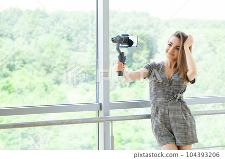 Smiling businesswoman looking at camera make conference business call Smiling businesswoman looking at camera make conference business call 104393206