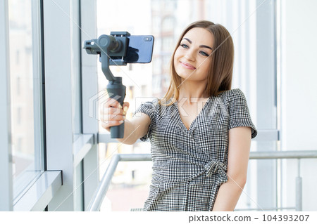 Smiling businesswoman looking at camera make conference business call Smiling businesswoman looking at camera make conference business call 104393207