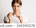 A young woman puts on contact lenses in her apartment 104393276