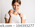 A young woman puts on contact lenses in her apartment 104393277