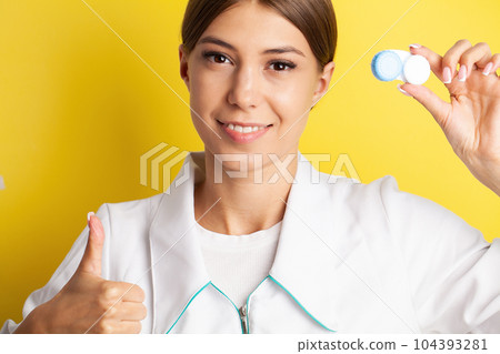 An ophthalmologist doctor shows contact lenses in his hand 104393281