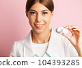 An ophthalmologist doctor shows contact lenses in his hand 104393285
