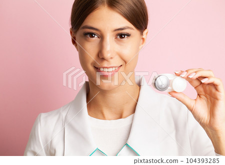 An ophthalmologist doctor shows contact lenses in his hand An ophthalmologist doctor shows contact lenses in his hand 104393285