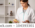 An ophthalmologist doctor shows contact lenses in his hand 104393301