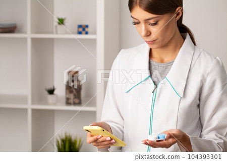 An ophthalmologist doctor shows contact lenses in his hand 104393301
