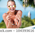 WOMAN spends time by the pool. in the background the ocean. summer holidays. 104393616