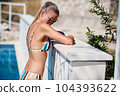 WOMAN spends time by the pool. in the background the ocean. summer holidays. 104393622